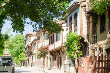 Fototapeta premium Beautiful old street in downtown with houses with wooden shutters in the classic Turkish Ottoman style, Turkey, center of Afyonkarahisar The two-storyed buildings