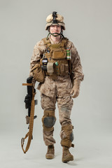 Soldier in camouflage holding rifle