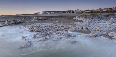 Sunset off the South Wales coast. Ogmore-by-Sea is a popular destination to swim and surf. A long shutter speed has been used to create a milky sea effect