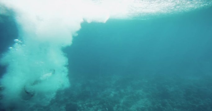 Underwater Footage of Man Jumping into Water and Swimming. Diving in the Coral Reefs. Shot on RED Epic 4K UHD Camera.