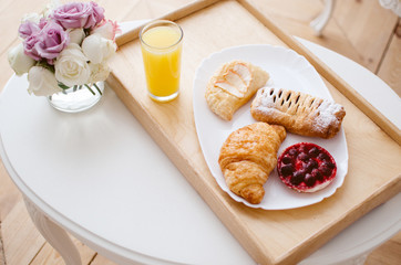 Breakfast in bed on a tray, freshly squeezed juice and croissants