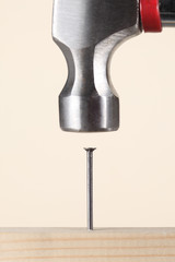 hammer fixing a nail in a wooden board