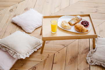 Breakfast in bed on a tray, freshly squeezed juice and croissants