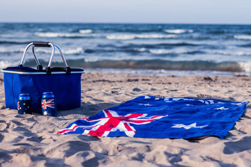 Australian flag beach towel with a picnic basket on the beach