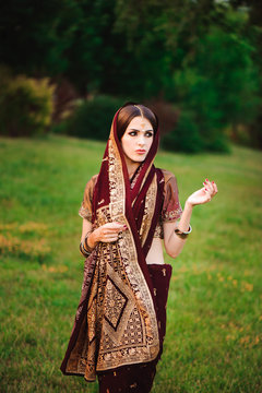 Beautiful Arabian woman portrait. Young Hindu woman with mehndi tattoos from black henna on her hands.