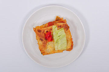 Lasagna with vegetables on a white