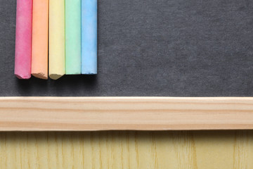 school concept: close up on a slate blackboard with chalks and copy space.