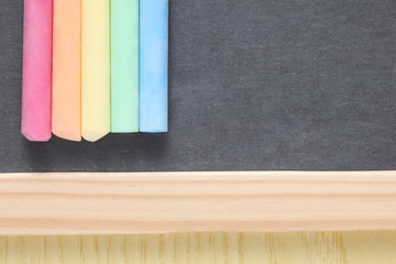 school concept: close up on a slate blackboard with chalks and copy space.