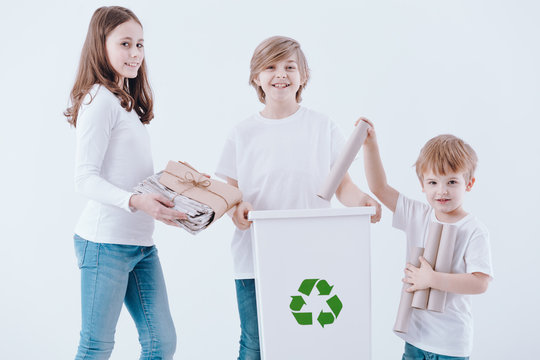 Smiling kids segregating paper waste