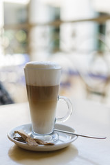 Glass of hot latte on a wooden table
