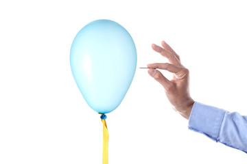finance burst concept: caucasian man's hand holding a nail burst a party balloon isolated with clipping path
