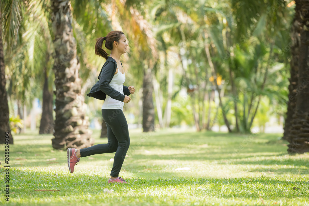 Wall mural pretty sporty woman jogging at park