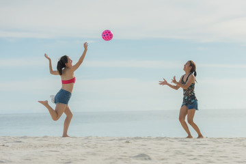 friend on a summer beach vacation playing with a beachball and having carefree fun