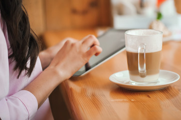 Close up hand woman using tablet in coffee shop