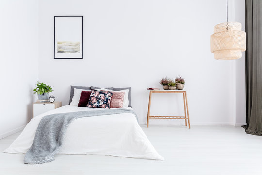 White bedroom with floral cushion