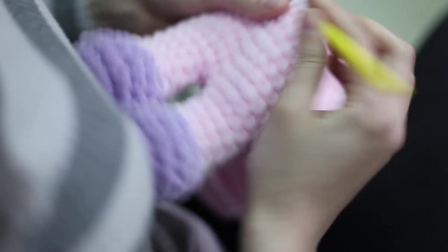 Young woman knitting amigurumi toy. Closeup