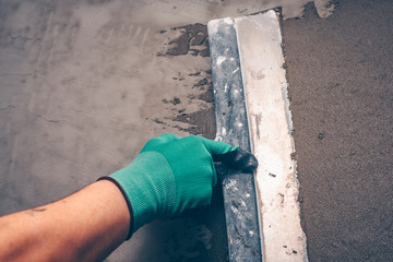 Tool for leveling the walls in the hands of the worker, working with a spatula, preparing the walls...