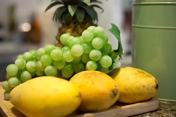 set of fruit; pineapple, white grape and mango are on the plate