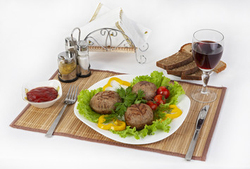 Meat of beef, round rhizol. Round meat cutlets with greens, tomatoes and a glass of wine. Useful and tasty breakfast.