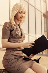 Young fashion business woman with file folder at office building
