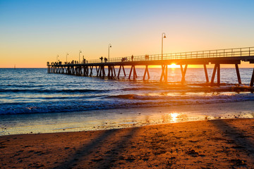 Fototapeta premium People walking along Glenelg Beach jetty