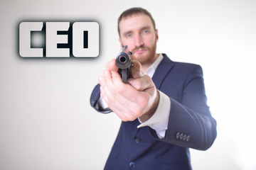 The businessman holds a gun in his hand and shows the inscription:CEO