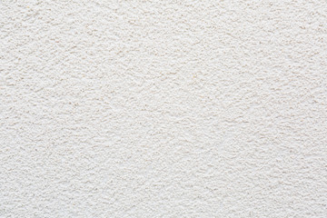 Pattern of white rock plastered stucco wall