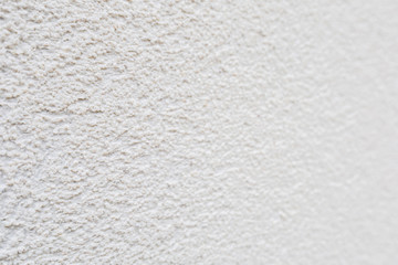Pattern of white rock plastered stucco wall