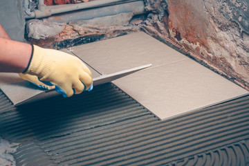 The tiler performs tile installation on the floor, finishing and facing works