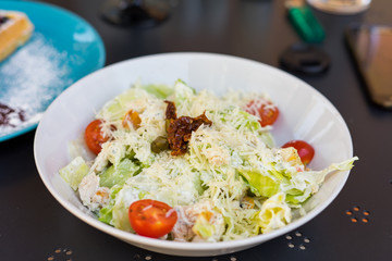 Fototapeta na wymiar Caesar salad with chicken, tomatoes, salad and parmesan