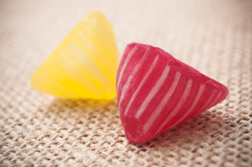 closeup of colorful traditional candies on hessian background