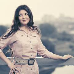 Happy young fashion woman in light pink shirt walking outdoor