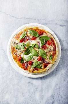 Pizza with mozzarella and gorgonzolla topped with spinach leaves