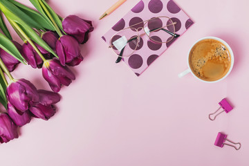 Flat lay on pink background with tulips and coffee