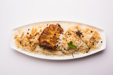 Authentic Fish Biryani served in a white plate over white background, selective focus