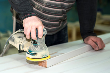 Wood processing. A man grinds a tree with a grinder