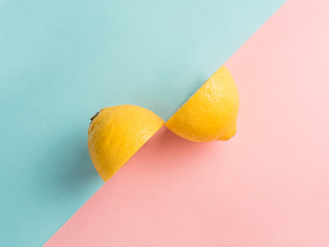 Two lemon halves on two-color background. Creative photo lemon. Top view. Lemon on blue and pink background. Top view or flat-lay. Copy space for text. Creative concept.