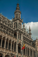 Richly decorated facade in Gothic style of Brussels City Museum and Belgian flag, at Grand Place. Vibrant and friendly, is the country’s capital and administrative center of the EU. Central Belgium