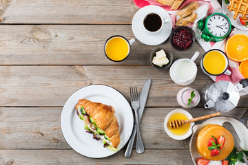 Fototapeta na wymiar Breakfast table with waffles, granola, yogurt, pancakes, juice, coffee
