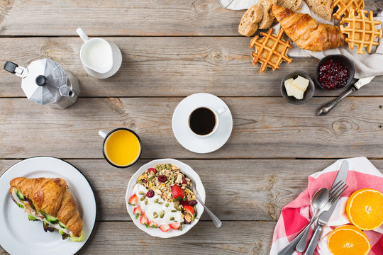 Breakfast table with waffles, granola, yogurt, pancakes, juice, coffee
