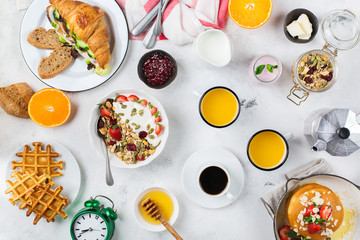 Breakfast table with waffles, granola, yogurt, pancakes, juice, coffee