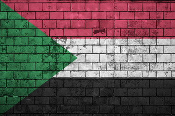 Sudan flag is painted onto an old brick wall