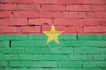 Burkina Faso flag is painted onto an old brick wall