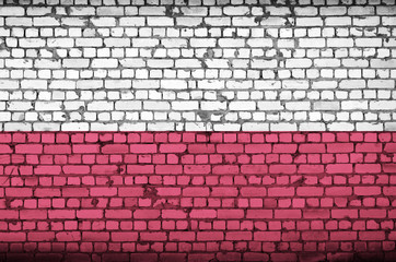 Poland flag is painted onto an old brick wall