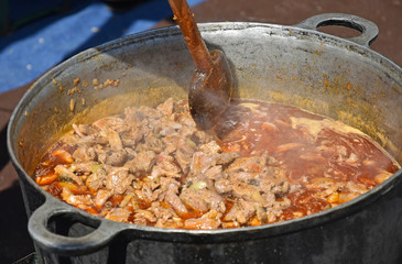 Cooking goulash outdoor in a cauldron