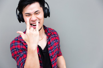 Portrait cool guy: Attractive handsome man listen rock music by using headphones. Charming man act like a rock star. Asia man get fun and relaxed. He is yelling, smiling and enjoying life, copy space