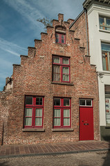 Naklejka premium Brick facade of house in typical style of the Flanders’s region in street of Bruges. With many canals and old buildings, this graceful town is a World Heritage Site of Unesco. Northwestern Belgium.