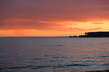 Beautiful bright orange summer sunset on the beach of Ob Sea, Siberia, Russia.