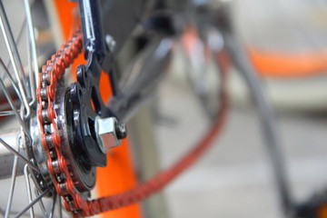 macro primo piano di bicicletta nera con catena arancione
