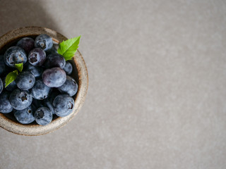 Fresh blueberries, in a ceramic bowl, on a gray background